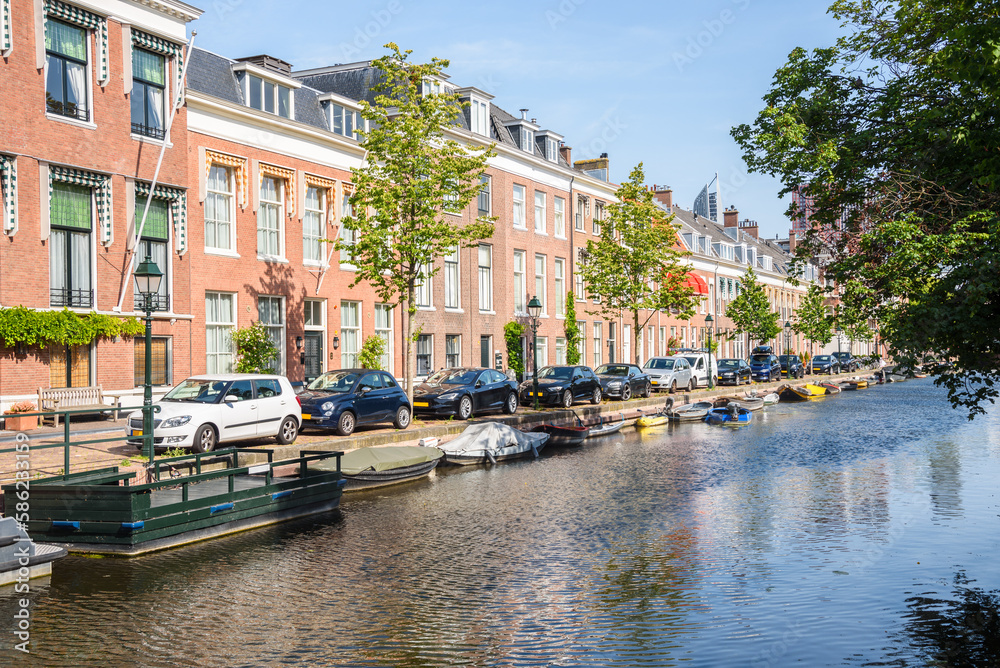 Row of brick townhouses along a canal on a clear summer day