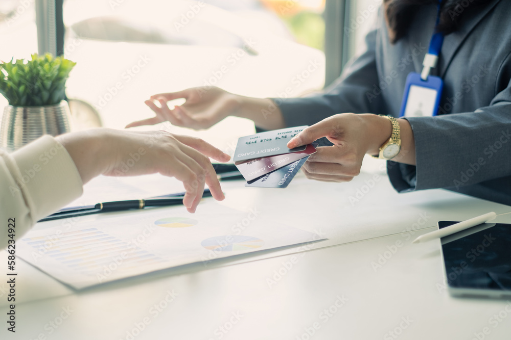 Fototapeta premium Asian business customer service representatives work serve sell credit card to customers. choosing insurance plan in office