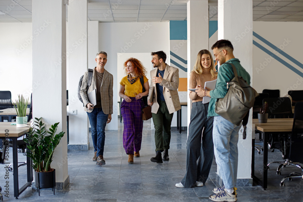 Fototapeta premium Happy business colleagues talking on the move in the office.