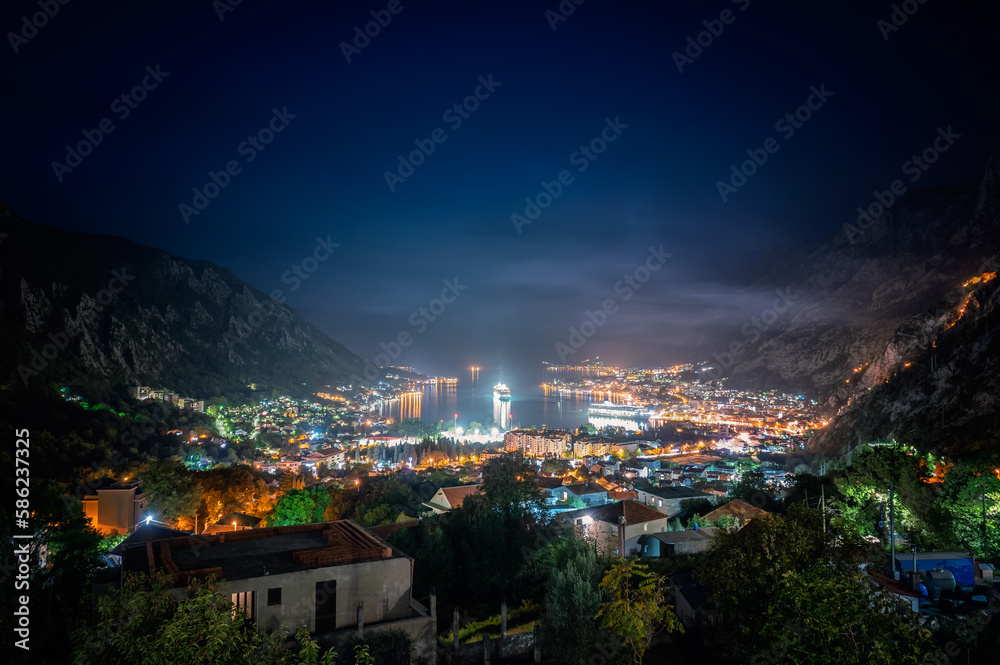 Fototapeta premium Amazing night view of the picturesque Bay of Kotor with the illuminated streets, buildings and cruise ships at the harbor.