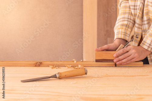 Workman using jack plane on wooden board. Crop faceless male carpenter smoothing wooden detail with jack plane