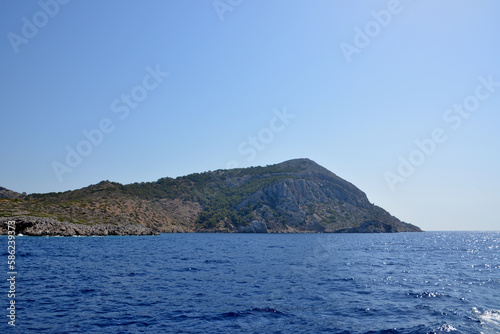 The island with mountain isolated with blue sea on foreground, copy space © Irina