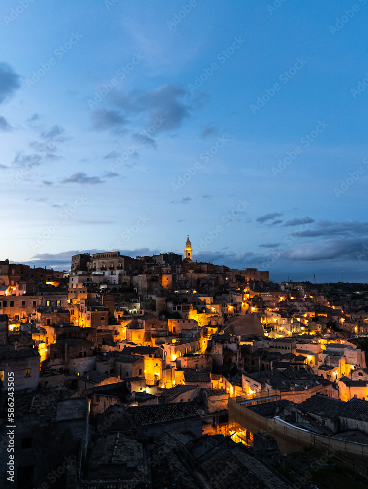 aerial view of the historic center in the city of matera while the sun sets and the lights of the historic houses turn on, basilicata, italy, sunset, night photography
