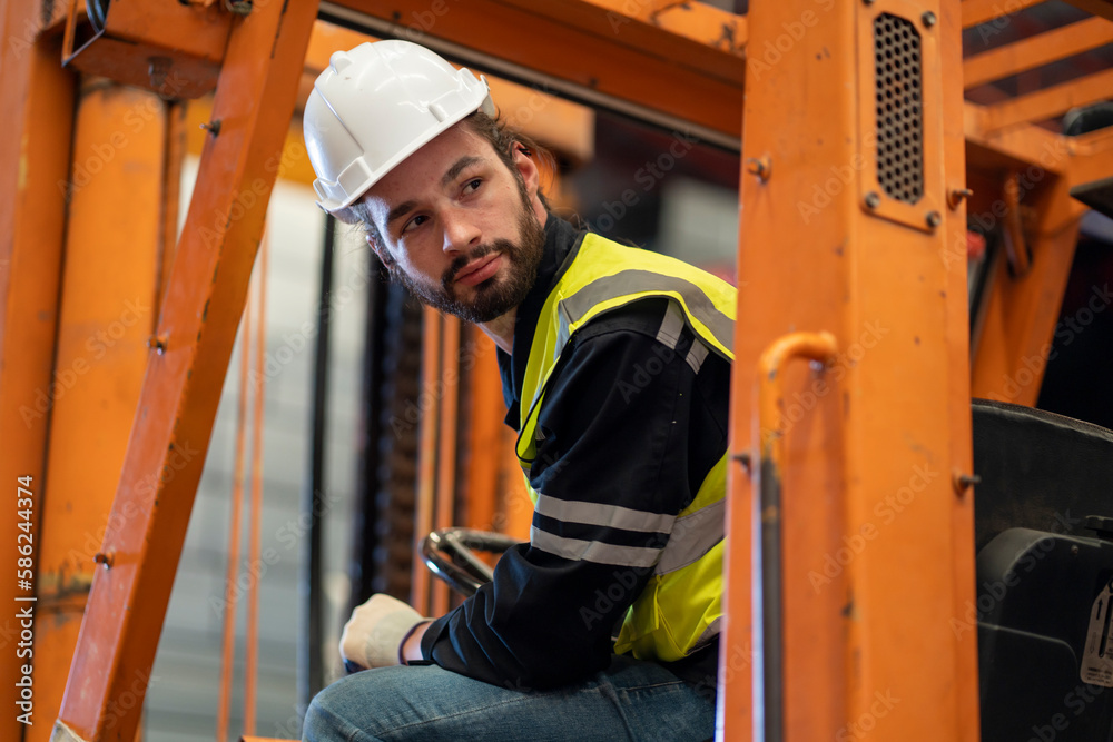Male worker driving a forklift in warehouse Male worker driving a forklift in warehouse