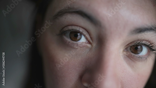 Woman close up eyes and face looking at camera. Female caucasian person in her 30s staring to lens
