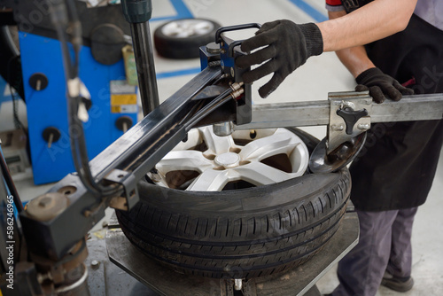Schilderij op canvas male car mechanic Changing 4 new tires in tire shop to change car wheels at serv