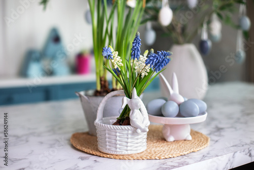 Canvas Print Flowers in vase, festive utensil and plate with easter blue eggs on table in kitchen