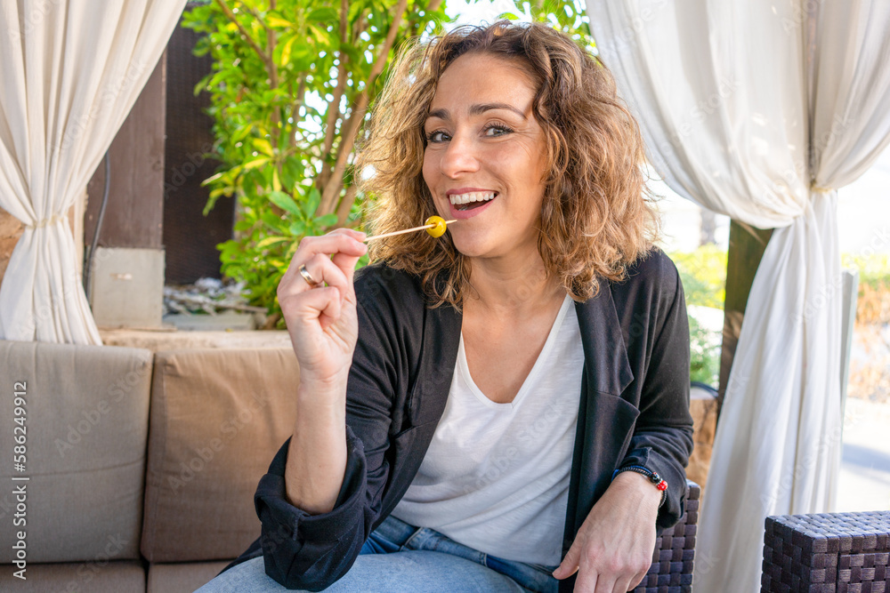 Fototapeta premium Beautiful young woman enjoying a snack in a outdoor restaurant