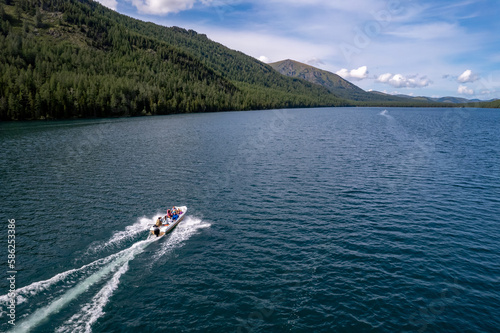 Speed boat move on beautiful Multinskoye lake in mountains Altai, Aerial top view © Parilov