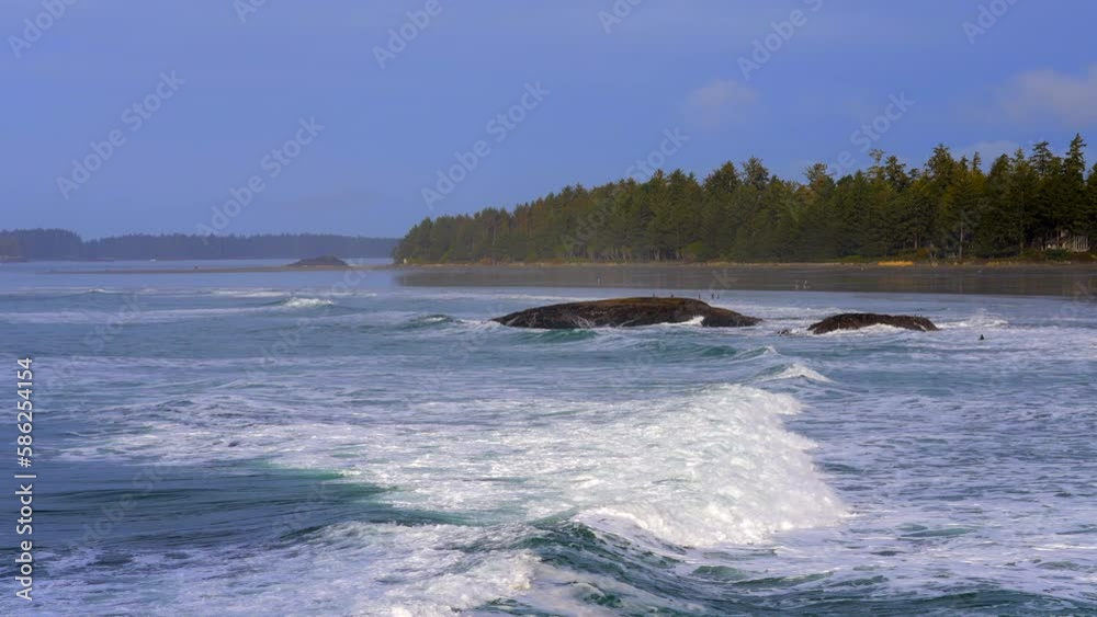 Establishing shot of ocean beach with waves and rocks in slow motion at summer day in Vancouver, Canada, North America. Day time on February 2023. Still camera. ProRes 422 HQ. Establishing shot of ocean beach with waves and rocks in slow motion at summer day in Vancouver, Canada, North America. Day time on February 2023. Still camera. ProRes 422 HQ.