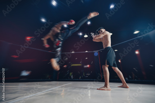 MMA Boxers fighters in fights without rules in ring cargo octagon hit kick, dark background spot light © Parilov