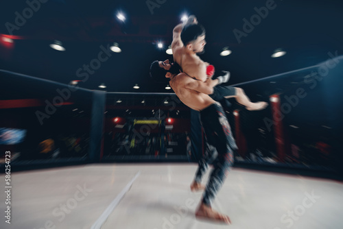 Boxers Aggressive fighter in MMA tournament in ring cargo octagon, dark background spot light © Parilov