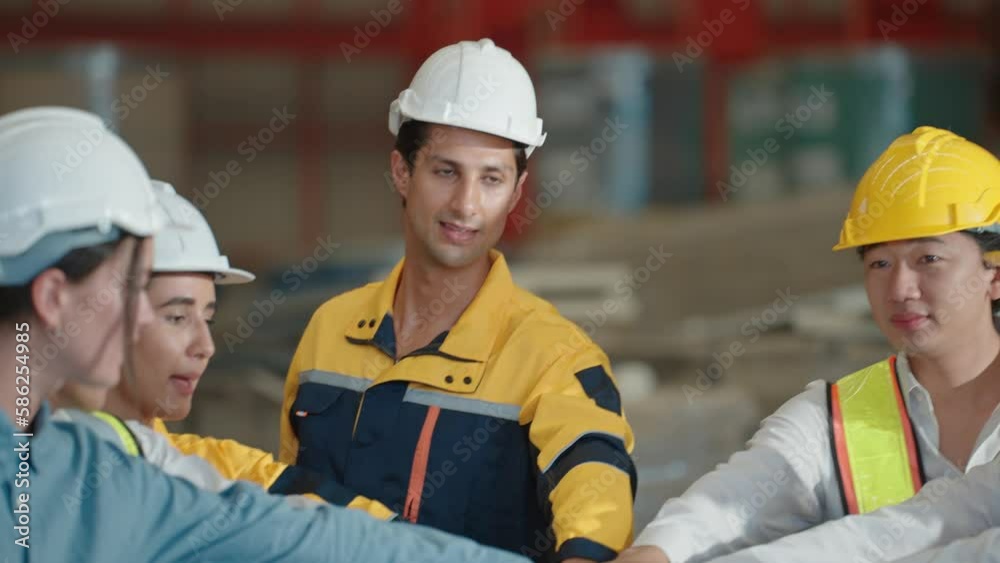 Happy Diversity unity engineer team wearing helmet standing and join hands to build successful projects at factory. Teamwork concept Happy Diversity unity engineer team wearing helmet standing and join hands to build successful projects at factory. Teamwork concept