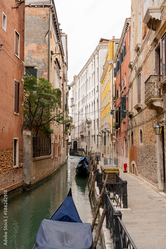 Venice canal between colorful facades and with gondolas