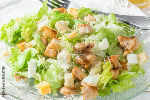 Caesar salad in a glass plate close-up