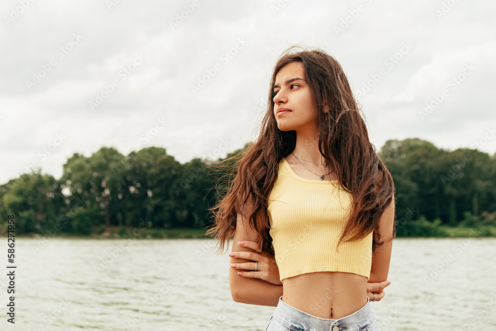 Obraz premium Slim woman walking barefoot along the river sea lake. Female on beach island with splashing waves and foam. Girl tourist on vacation, weekend relaxing resting resort. Lady go on shore, sunbathing