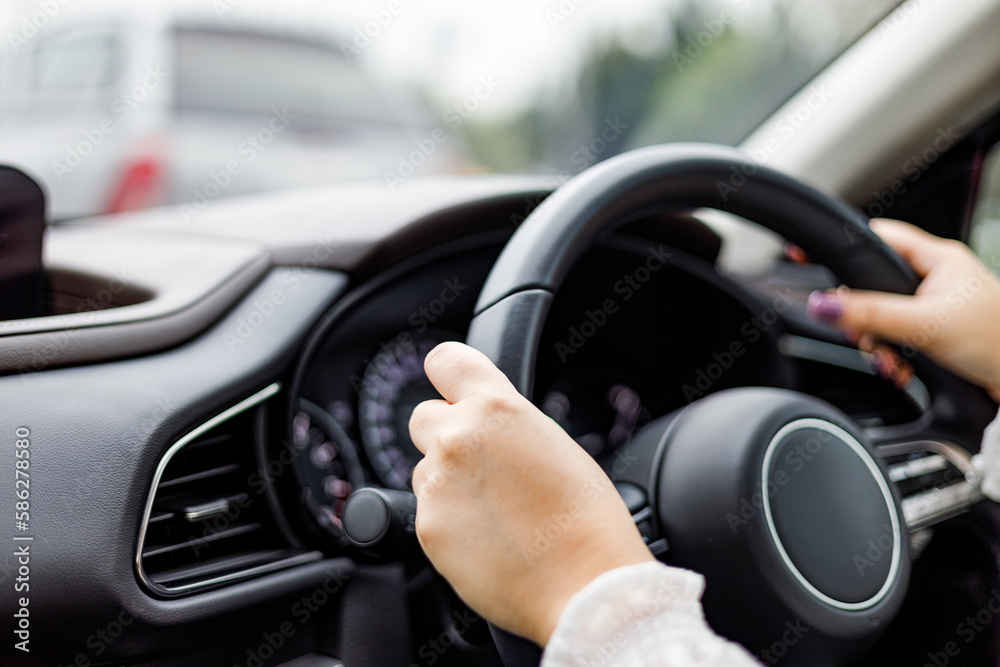 Close up hands of woman driving a car..