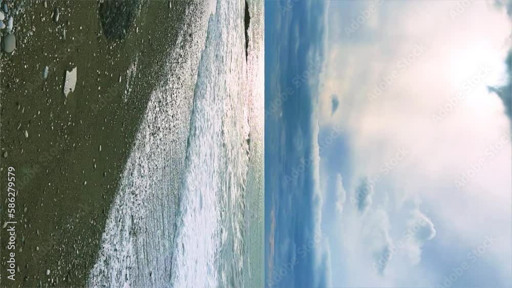 Powerful sea waves are crashing on the Black Sea coast. Waves splash on the beach with pebbles during a storm. Storm at sea. Panoramic view of the Black Sea. Russia. Sunset on the beach. 4K