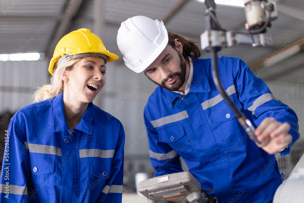Engineer team man and woman working together training help support work with robot welding machine service. Engineer team man and woman working together training help support work with robot welding machine service.
