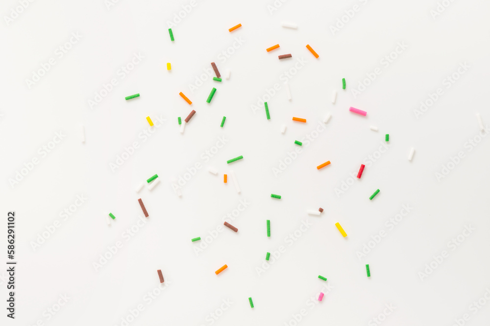 flat lay of colorful sprinkles over white background, festive decoration for banner, poster, flyer, card, postcard, cover, brochure, designers flat lay of colorful sprinkles over white background, festive decoration for banner, poster, flyer, card, postcard, cover, brochure, designers