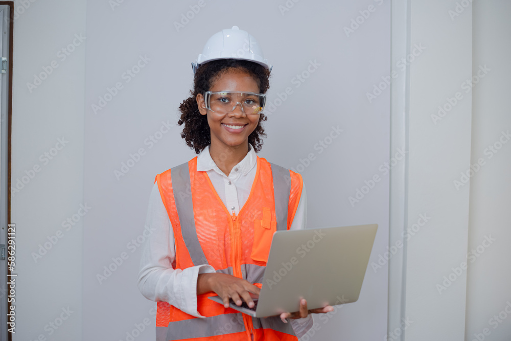 Engineering African American businesswoman holding digital tablet and computer in hands. African American woman builder using touchpad, Constuction, Engineering African American businesswoman holding digital tablet and computer in hands. African American woman builder using touchpad, Constuction,