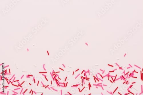 flat lay of pink sprinkles over background, festive decoration for banner, poster, flyer, card, postcard, cover, brochure, designers, copy space