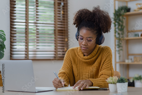 Young African American woman with wearing headphones and laptop at desk in office  Online education  Young African American.