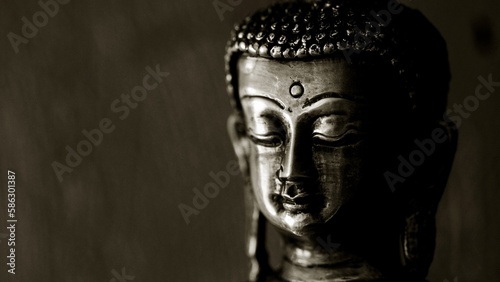 Traditional bronze Buddha statue isolated on black background.