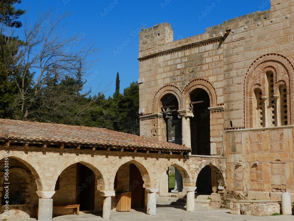 View of the 11th century Dafni Byzantine monastery in Attica, Greece. The column is from the ancient temple of Apollo