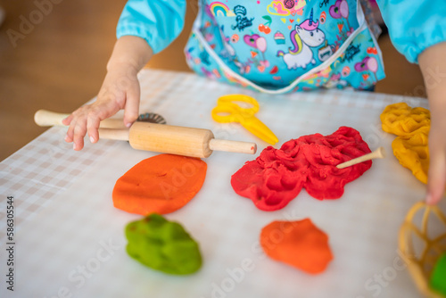 A little girl playing with plasticine. Sensory development and experiences, themed activities with children, fine motor skills development