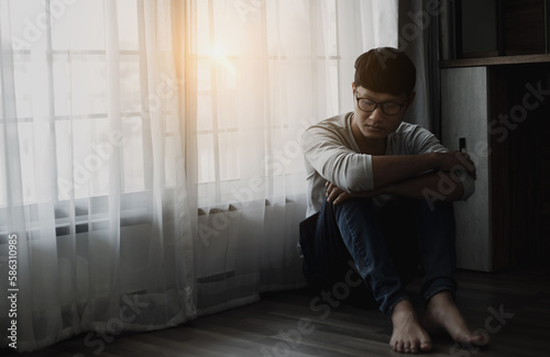 Sad young man sitting in the bedroom, People with depression concept, stressed man, 