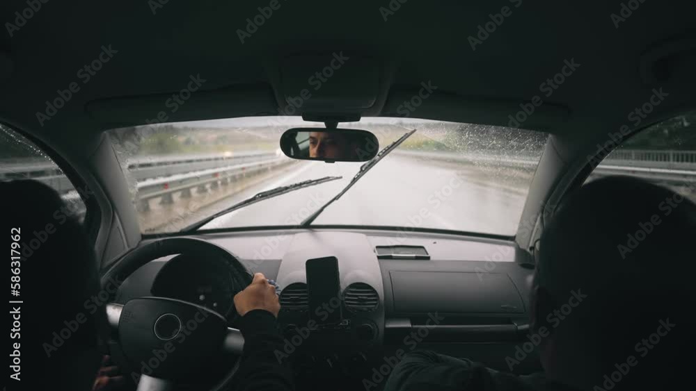 Business people drive oldtimer on highway road at rainy weather. Windshield wiper clean rain drops from glass, slow motion