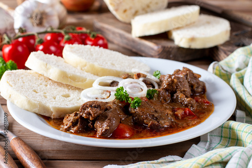 Homemade hot Czech goulash with knodel in a plate close-up. horizontal