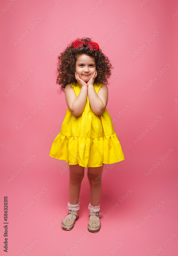portrait of a girl in a yellow dress cute attractive cute cheerful cheerful little girl .isolated pink background. portrait of a girl in a yellow dress cute attractive cute cheerful cheerful little girl .isolated pink background.
