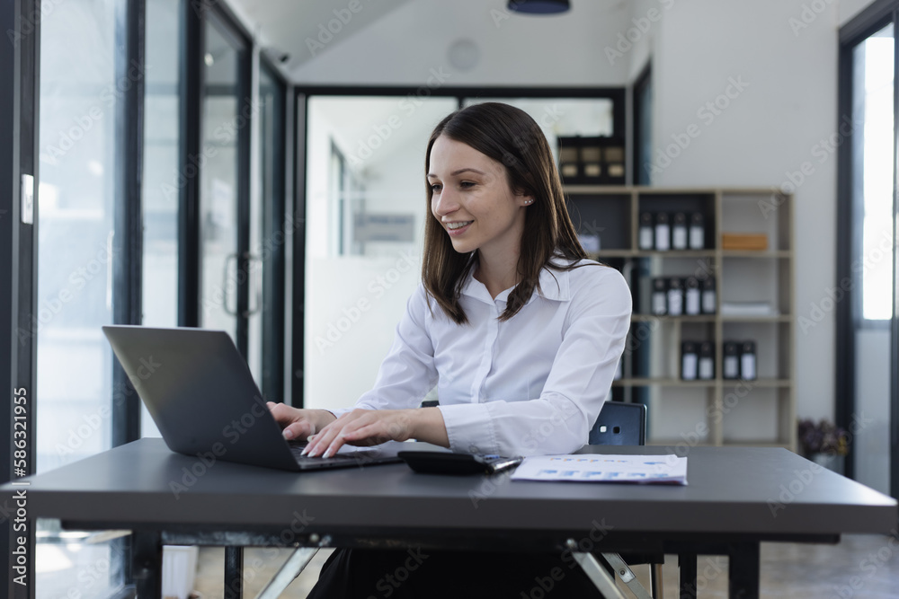 Happy excited young successful business woman and working online at the table in office, Happy excited young successful business woman and working online at the table in office,