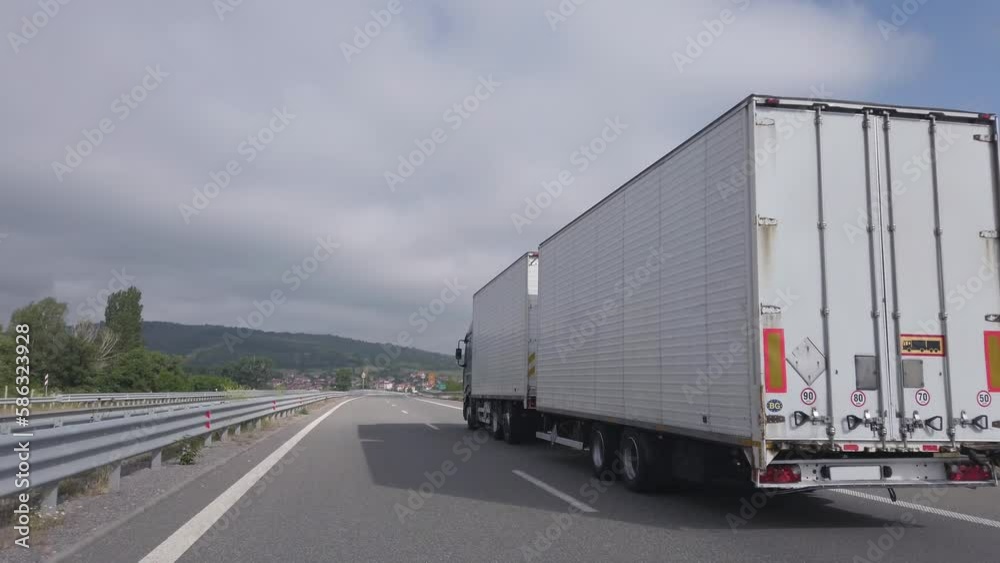 Long white truck with trailer drive shipping goods on highway, cinematic shot Long white truck with trailer drive shipping goods on highway, cinematic shot