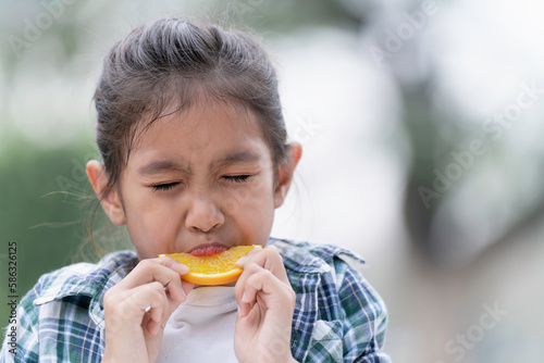 The girl is eating oranges, eating fruit for health.