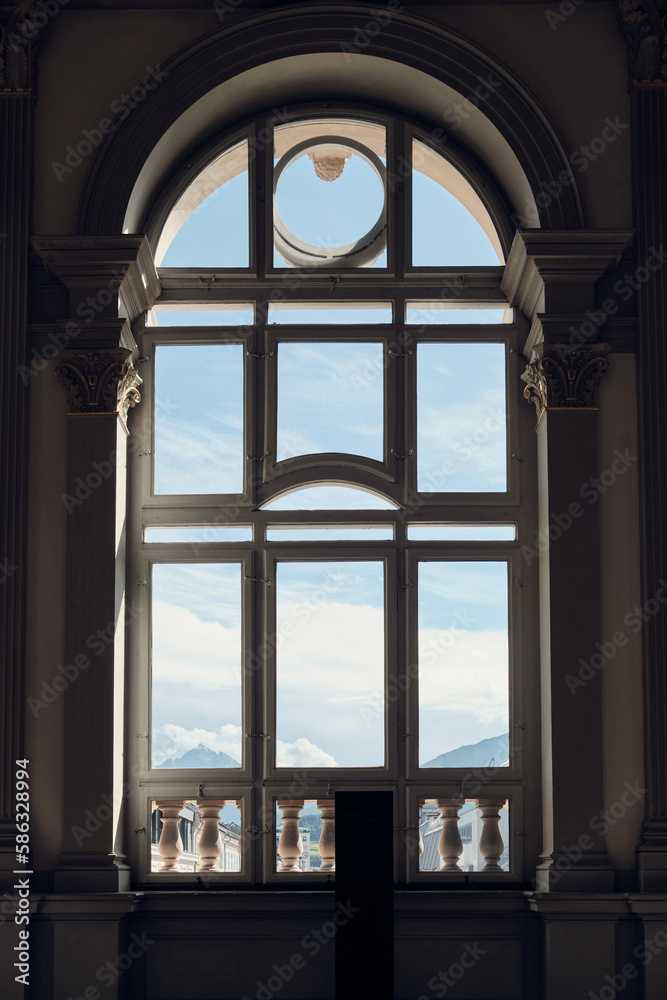 Fototapeta premium Cloudy sky seen through a tall, ornate window