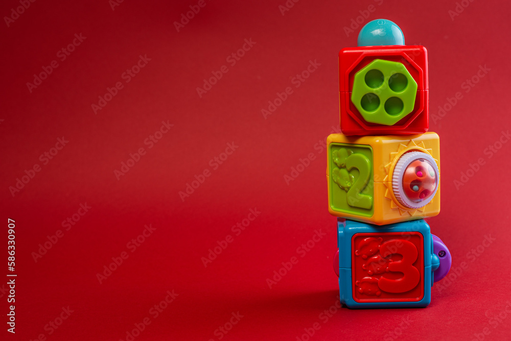Obraz premium Color cube toy tower on red background.