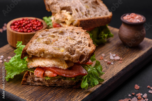Delicious sandwich with crispy toast, chicken, tomatoes and lettuce
