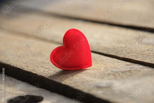 Red heart on a wooden background. Place for text. Valentine. Birthday background.