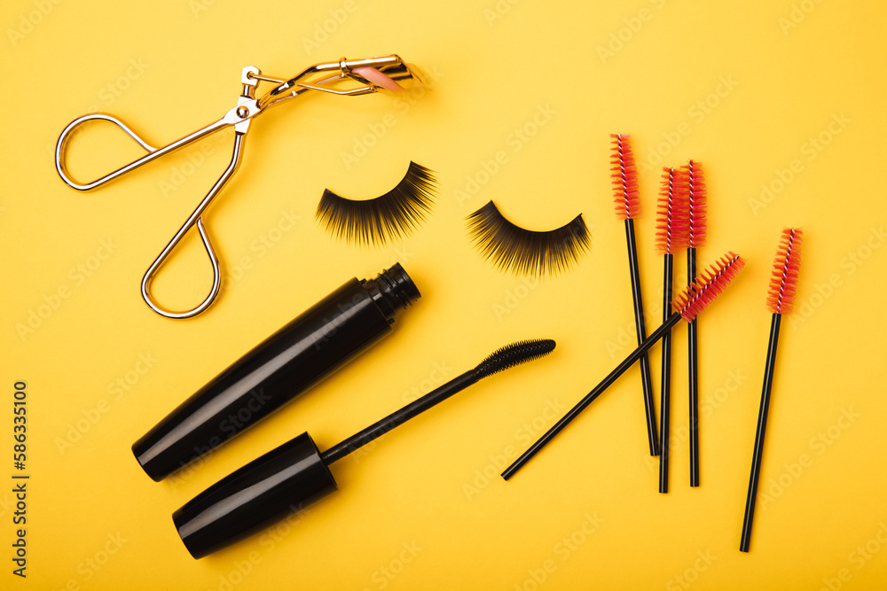 Composition with false eyelashes, mascara and eyelash brushes, eyelash curlers on a yellow background. Makeup artist tools. Beauty concept. Compose. Place for text. Place to copy. Flatley. MOCAP. Composition with false eyelashes, mascara and eyelash brushes, eyelash curlers on a yellow background. Makeup artist tools. Beauty concept. Compose. Place for text. Place to copy. Flatley. MOCAP.