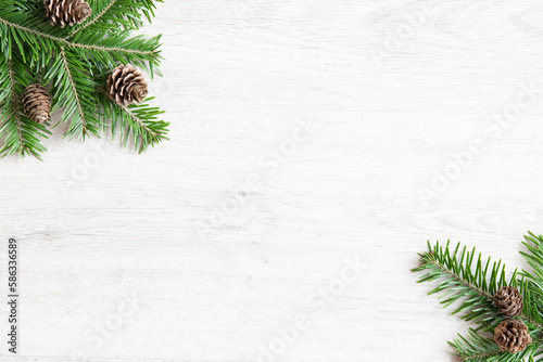 Background of Christmas tree branches. Christmas banner with branches and pine cones arranged diagonally.