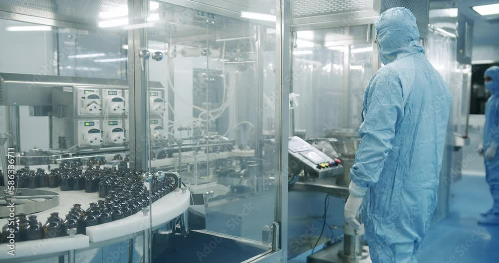Factory Cleanroom. Pharmaceutical, Biotechnological and Semiconductor Creating Manufacturing Process. Scientists in Sterile Protective Clothing Work on a Modern Laboratory.