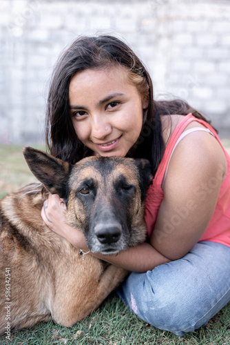Portrait of a young Hispanic woman hugging her one-eyed dog in the garden © Miguel Serrano