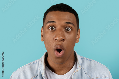 Portrait of shocked surprised funny silly millennial black guy with open mouth looking at camera