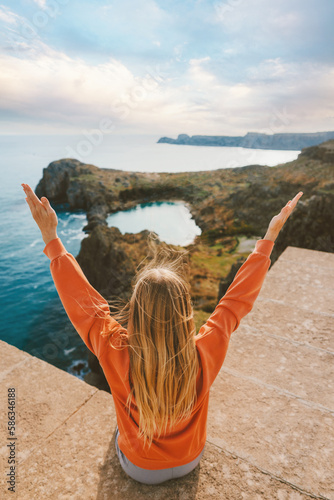 Woman tourist sightseeing Rhodes island travel in Greece outdoor healthy lifestyle active vacations girl raised hands enjoying St. Paul's bay aerial view landscape