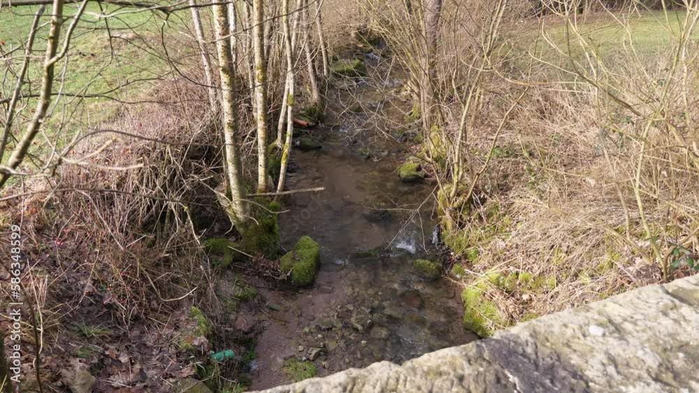Water flowing in a small brook under a stone bridge Water flowing in a small brook under a stone bridge