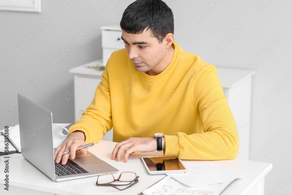Young man working on laptop in office Young man working on laptop in office