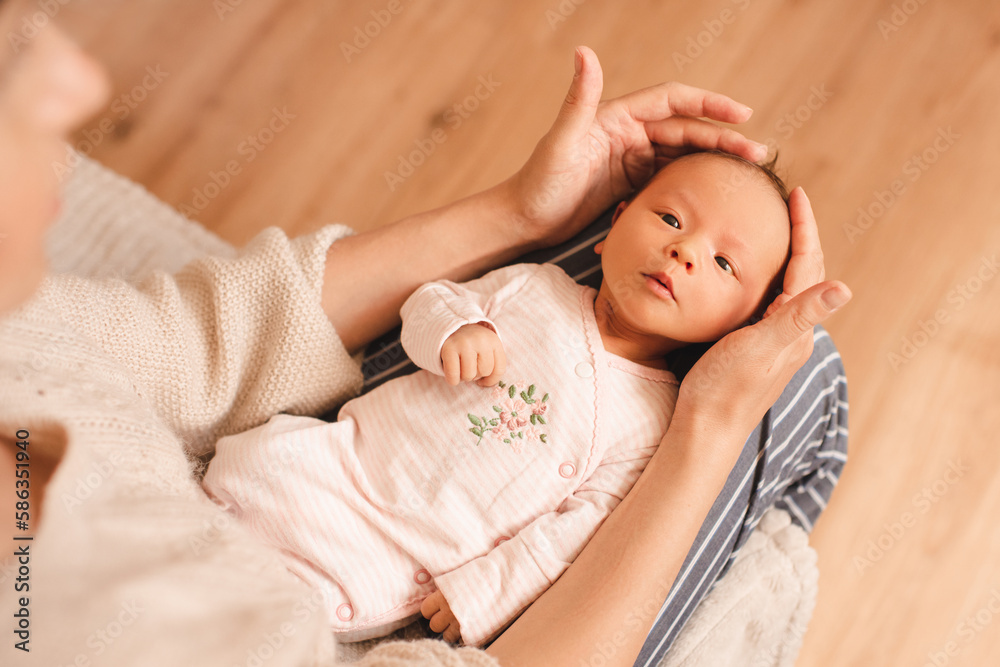 Mother holding cute infant baby girl on hands wear pajamas in room at home top view. Motherhood. Mother holding cute infant baby girl on hands wear pajamas in room at home top view. Motherhood.